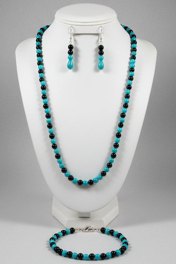 Jewelry set with turquoise and black beads on a mannequin bust.