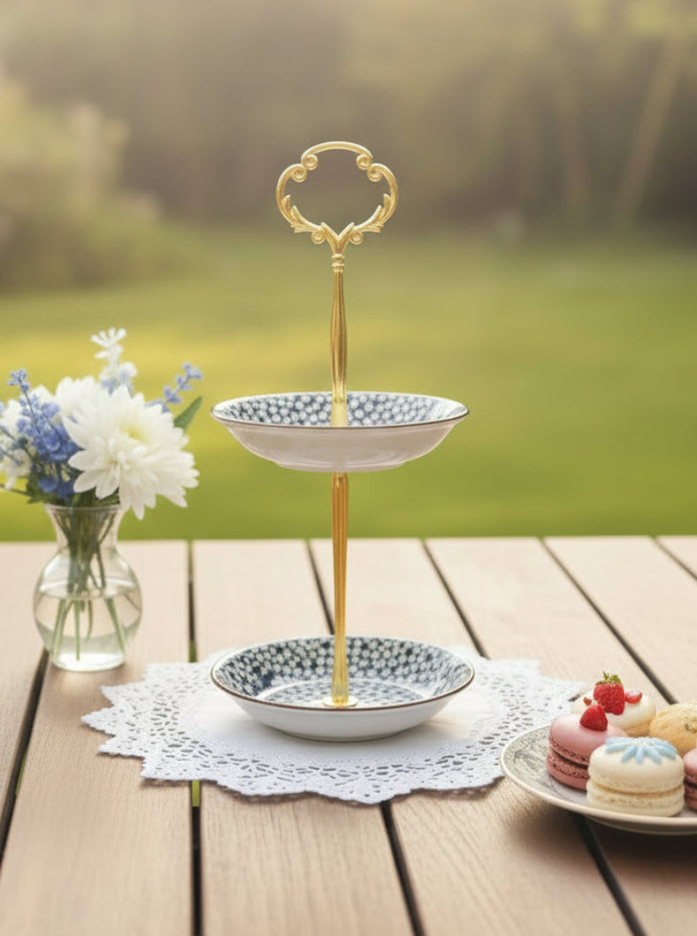 Two-tiered decorative stand with floral patterns on a table.