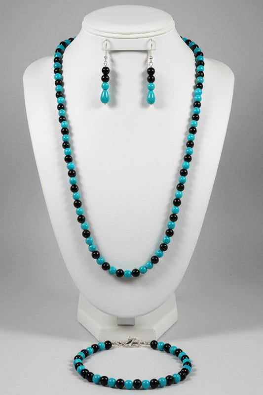 Jewelry set with turquoise and black beads on a mannequin bust.