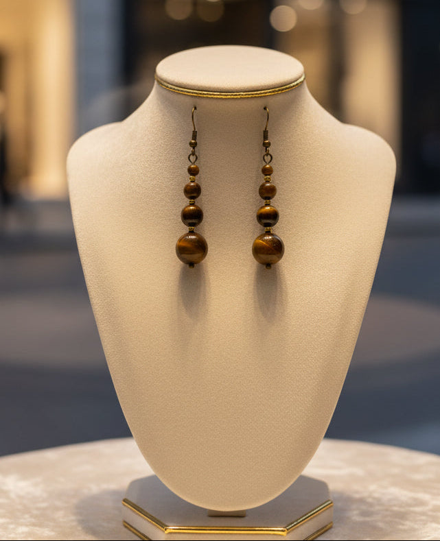 Pair of beaded earrings on a mannequin bust.